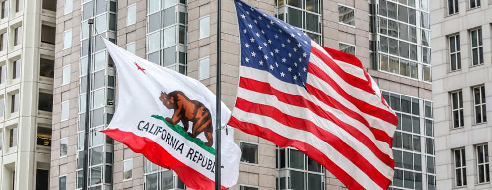 California and American flags waving in front of a building