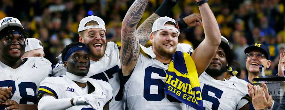 Michigan Wolverines offensive lineman Zak Zinter raises the championship trophy after Michigan wins the Big Ten Championship Game against the Iowa Hawkeyes on December 2, 2023, at Lucas Oil Stadium in Indianapolis, IN.