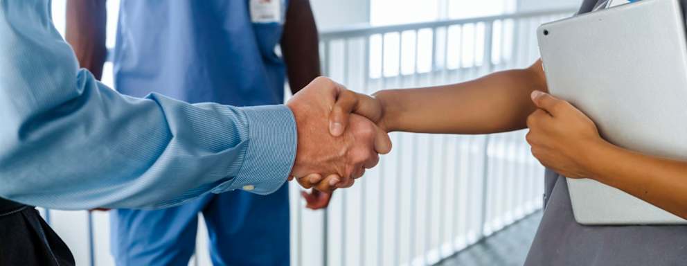 Nurse shaking hands with business professional