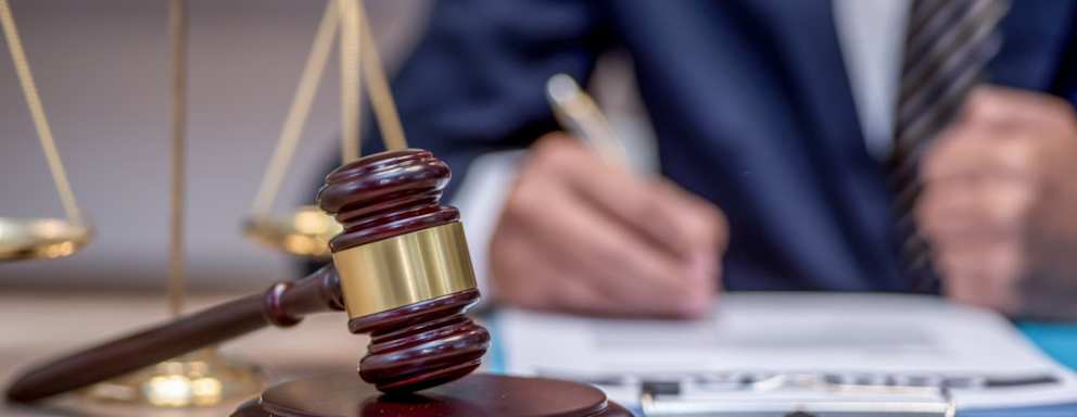 Judge signing papers beside gavel