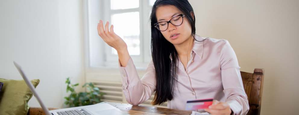 Woman looking frustrated while using a credit card