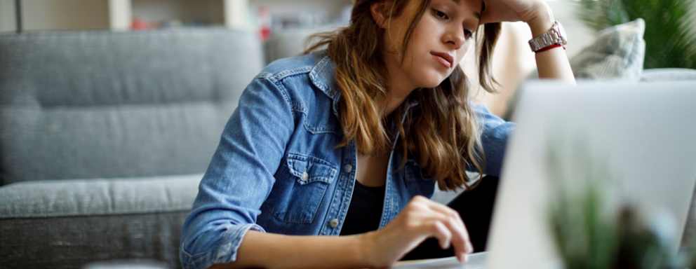 Worried young woman working at home