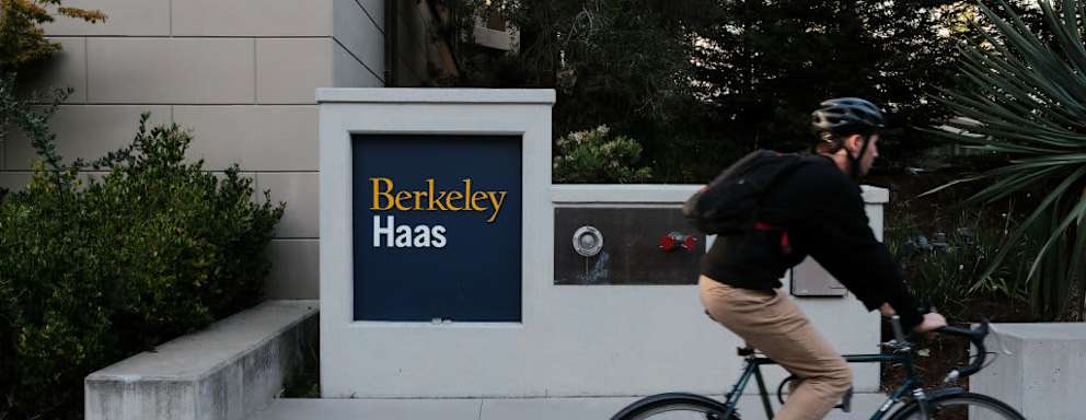 Biker passes sign for Berkeley Haas