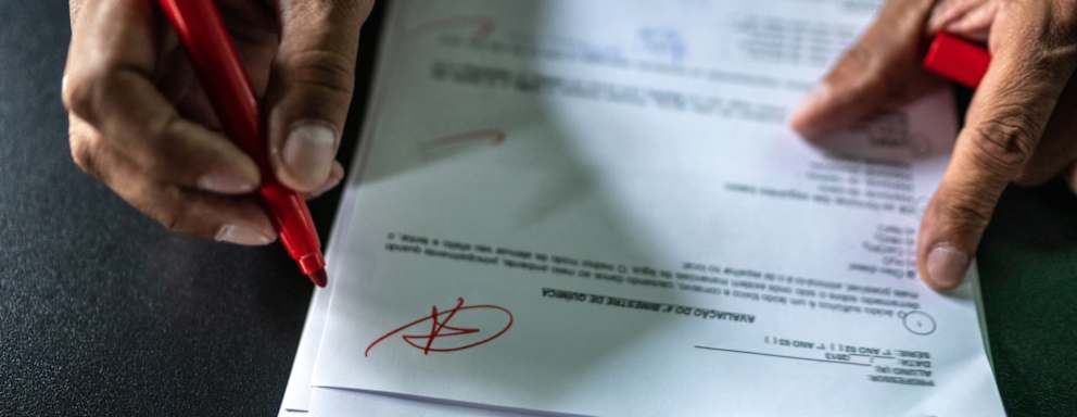 Instructor grading an assignment with a red pen