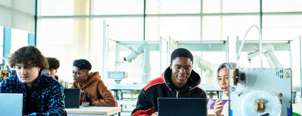 Students using laptop in technical college class