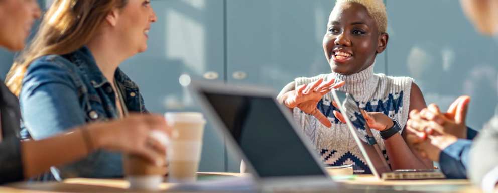 Cheerful woman in her 20s in business meeting with colleagues, teamwork, discussion, connection