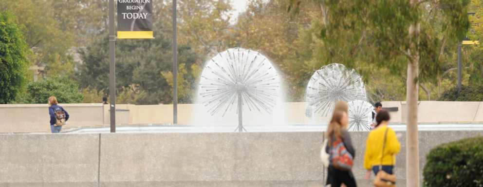 Students walking near the water fountain on the campus of California State University Long Beach.