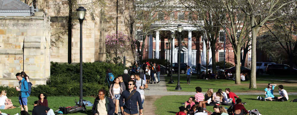 Students walking to class on a sunny spring day near Sterling Library on the Yale University campus.