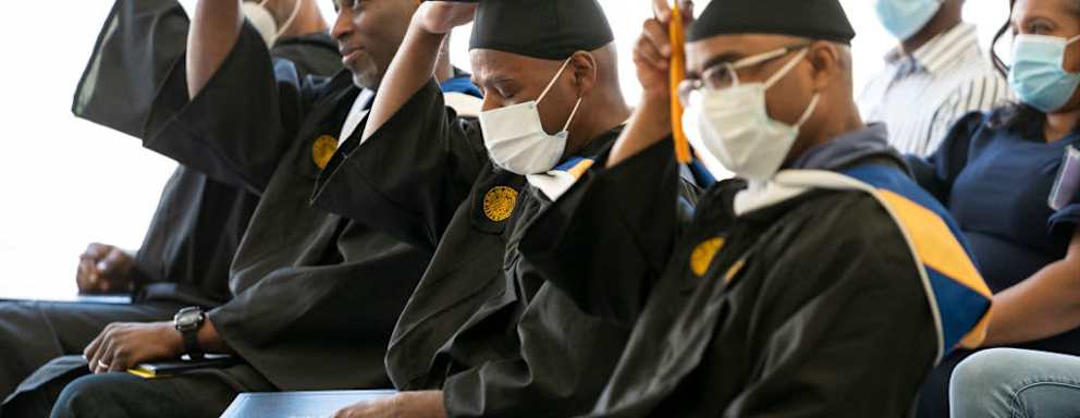 Graduates of the Goucher Prison Education Program for 2021 and 2022 move their tassels during the graduation ceremony held at the Maryland Correctional Institution-Jessup in Jessup, MD on May 18, 2022. James Scott, Nyol Robinson, James Jackson and Walter L. McCoy, Jr. received their degrees in American Studies from Goucher College while serving time in prison.