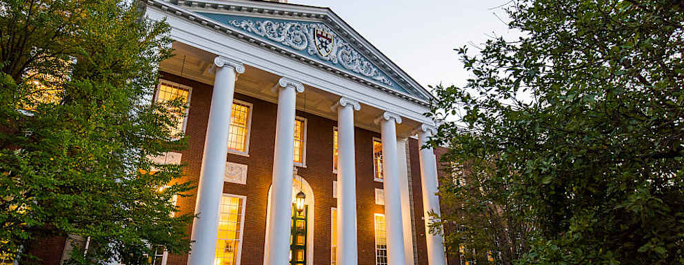 Students walking to and from class at the Baker Library/Bloomberg Center Complex on a clear evening at the Harvard Business School in Boston, Massachusetts.