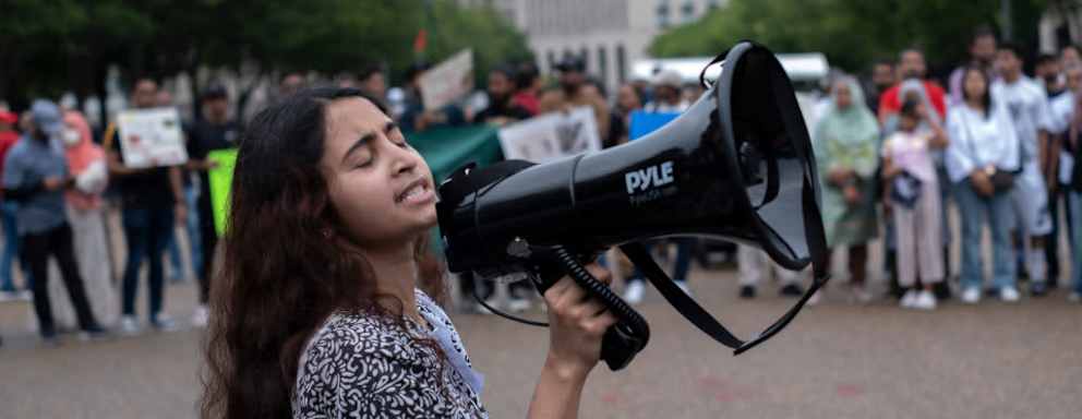 A female Bangladeshi student shouts slogans in front of the White House while joining in a demonstration. Bangladeshi students gathered with banners and Bangladeshi flags in front of the White House on July 20, 2024, as they showed solidarity with Bangladesh students anti-'Quota' protest. More than one hundred people have been killed in the clashes so far across Bangladesh and over 1,500 have been injured by the authoritarian government during a movement demanding reform of the quota system in government jobs.