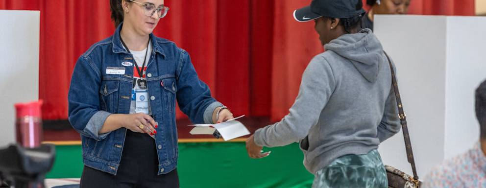 Poll workers assist a voter on Super Tuesday at the First Ward Creative Academy on March 5, 2024 in Charlotte, North Carolina.