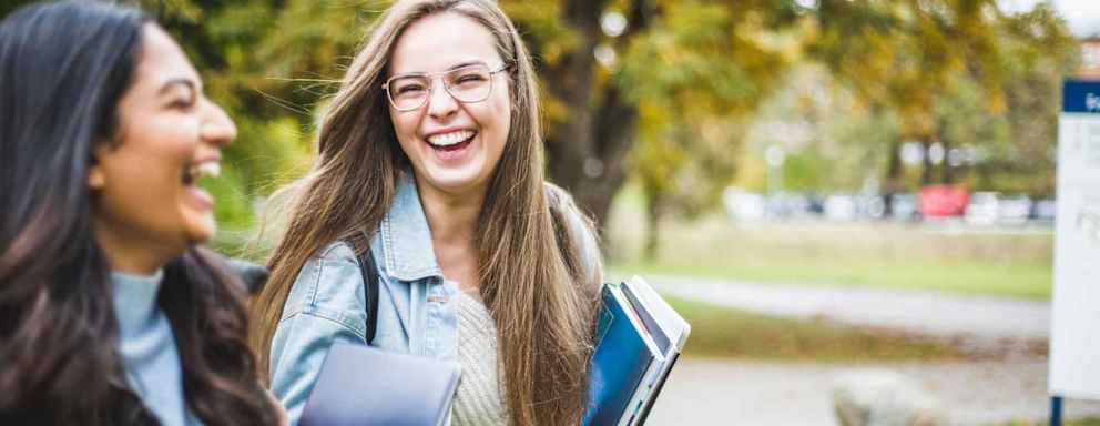 Happy young female friends in university campus