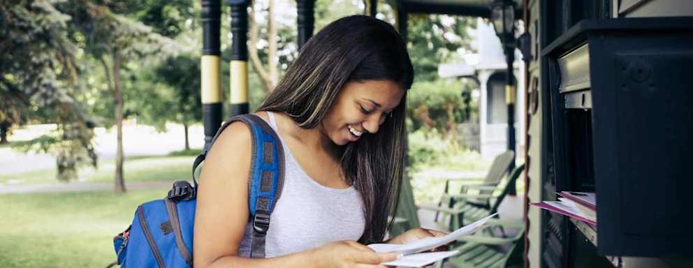 Teenage girl receiving letter of acceptance for college in mail