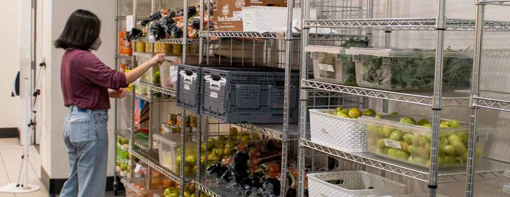 College student at food pantry choosing from a variety of healthy foods