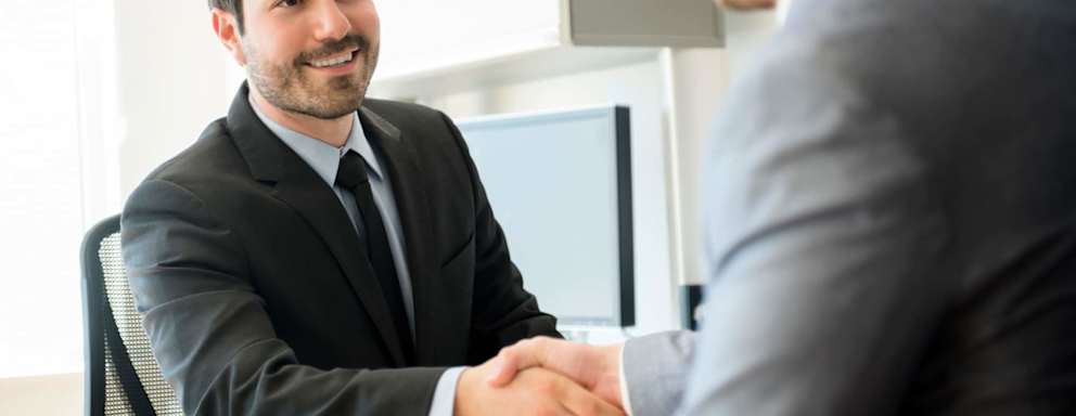Two business men shaking hands in an office.