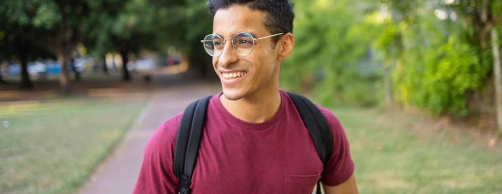 Portrait of a handsome man laughing and toothy smiling. He is looking away