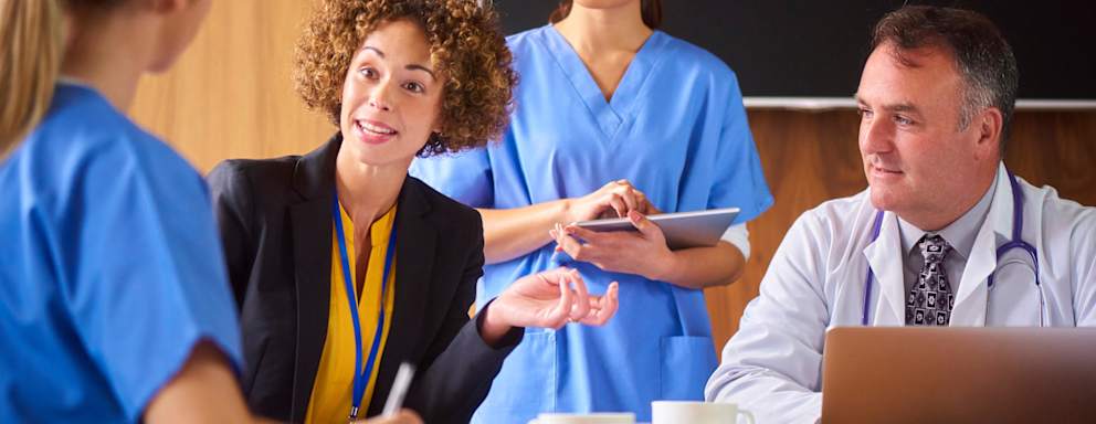 Medical and nursing teams hear presentations from business in the hospital board room.