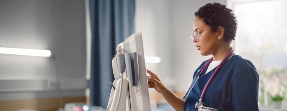 Nurse using touch screen computer in patient room