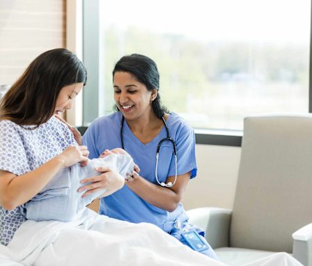 Postpartum nurse caring for newborn baby and mother