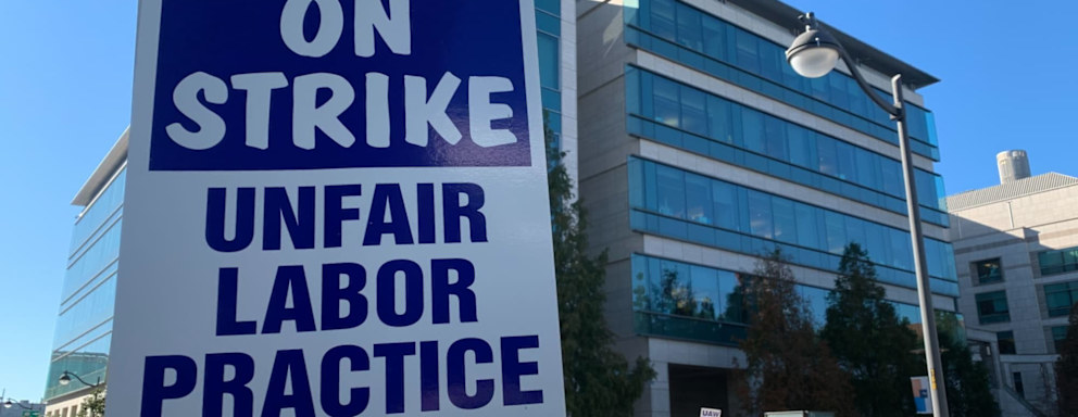 Academic workers hold signs and march at a strike in front of the University of California San Francisco campus administrative office to demand higher wages and more benefits for international students and working parents.