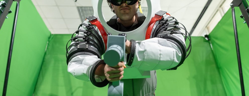 Mangili hanging from a crane in the mixed reality lab in his space suit