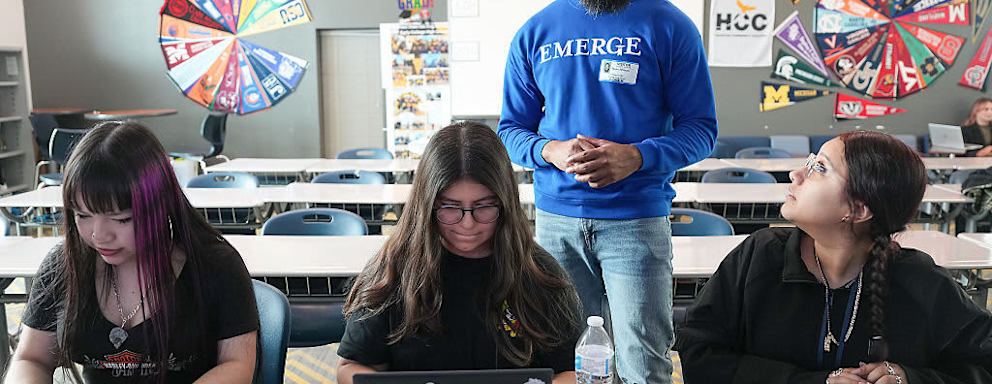 Emerge program manager D.J. Johnson talks to Sterling Aviation Early College seniors Katherine Garcia, (from left), Angela Ojeda and Valeria Castillo about scholarships at their school in Houston on Thursday, April 3, 2025.