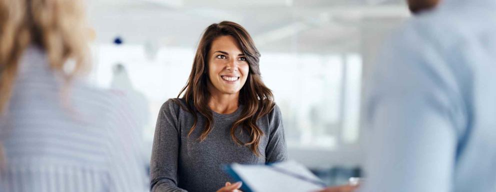 Young female candidate talking to human resource team during a job interview in the office.