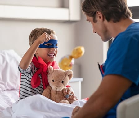 Pediatric nurse helping a kid dressed as a superhero