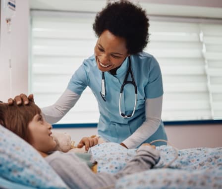 Nurse touching a child patient's head and smiling