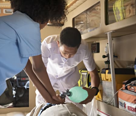 Nurse administering CPR on patient in ambulance