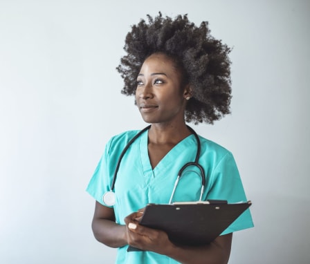 Portrait Of Female Nurse Wearing Scrubs In Hospital.
