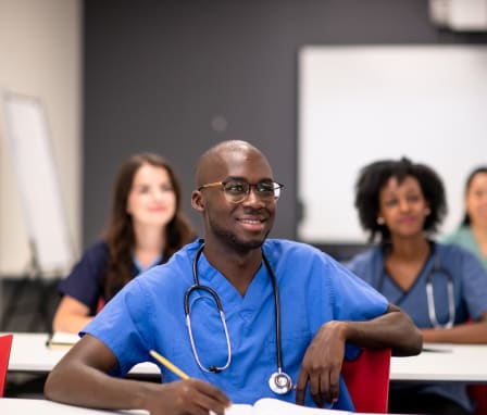 Male nurse in classroom taking notes