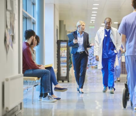 CNO talking to nurse in hospital hallway