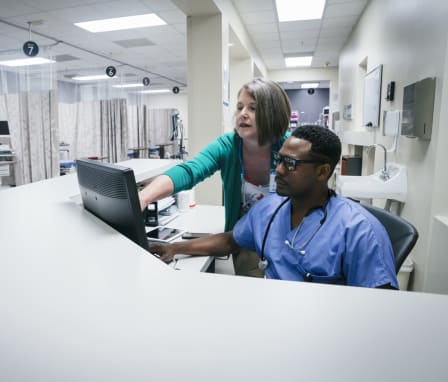 Nurse and doctor checking a computer in the emergency room