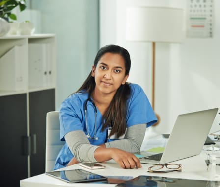 Nurse smiling at computer desk