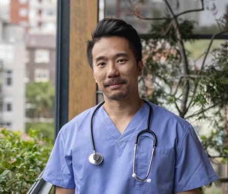 Male nurse standing outside of a hospital