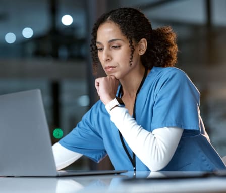 Nurse studying on laptop at night