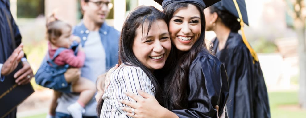 Nursing school graduate hugging her mom at commencement