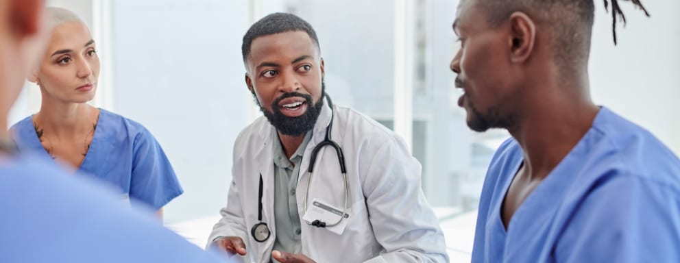 A doctor talking to nurses in a meeting