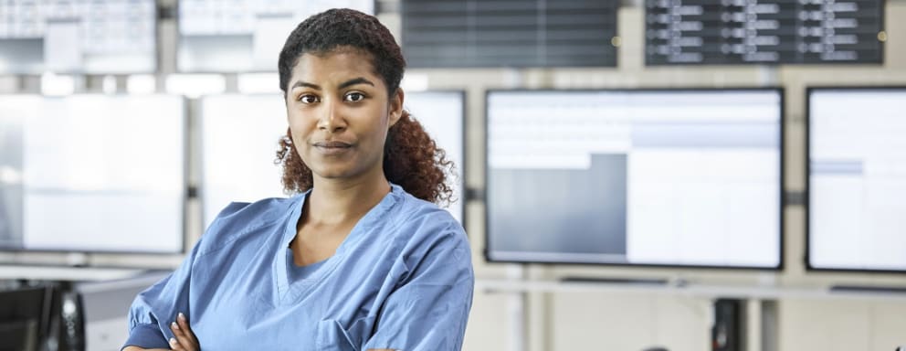 Nurse standing in front of a wall of computer monitors