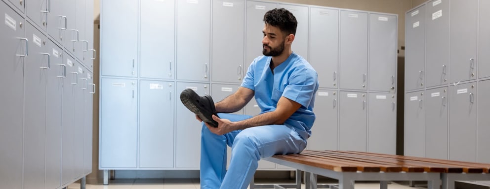 Nurse putting shoes on in locker room