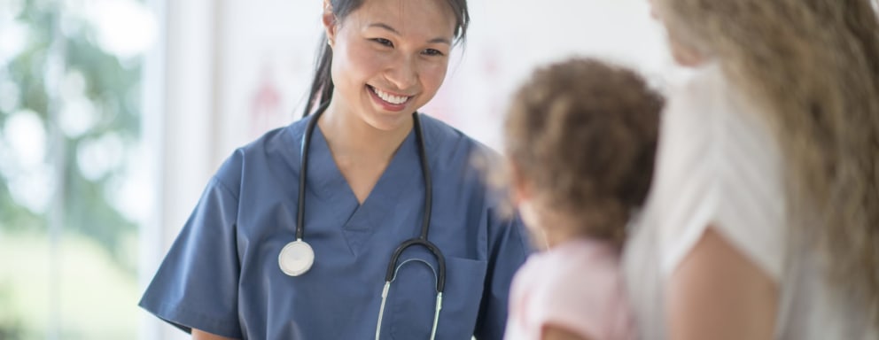 Nurse caring for a foster child and smiling