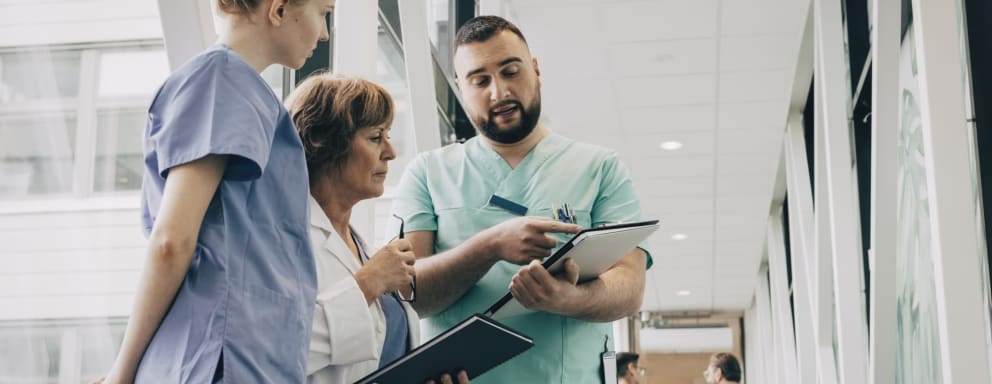 Nurses and doctor reading from a clipboard