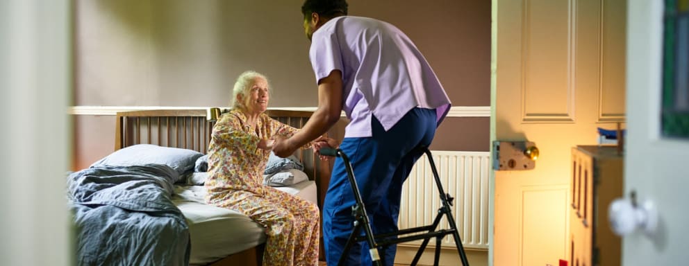 Nurse helping nursing home resident out of bed