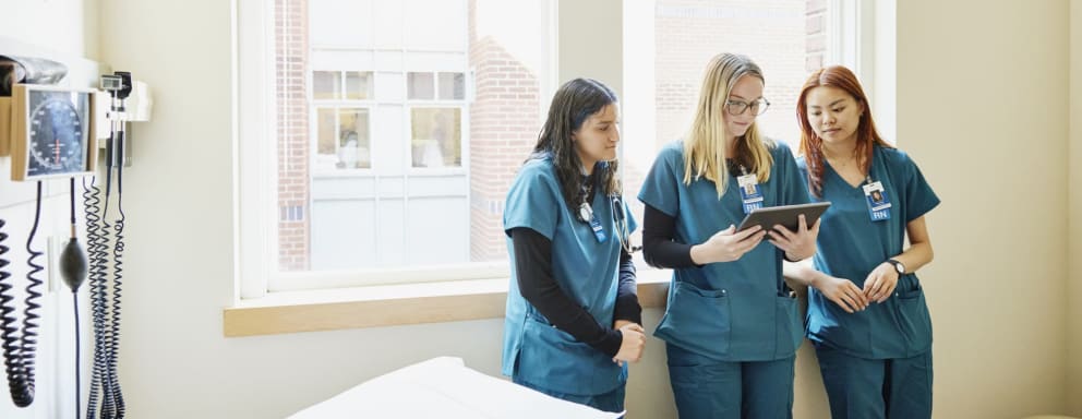 Nurses talking together and looking at a tablet