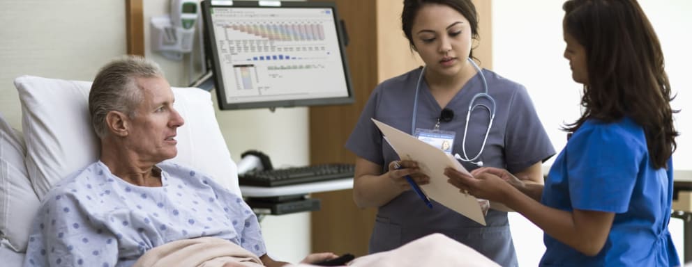 Nurses in VA hospital talking to patient