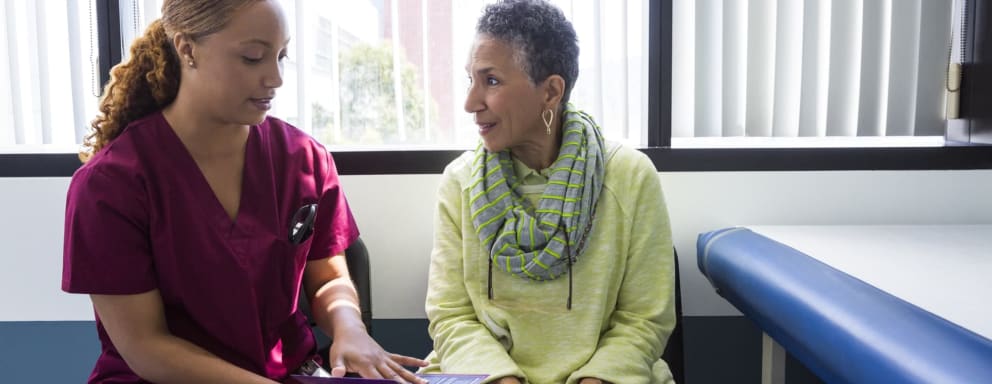 Black nurse talking to black patient