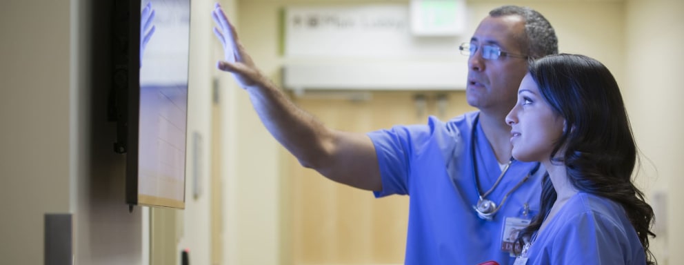 Nurses looking at staffing schedule board