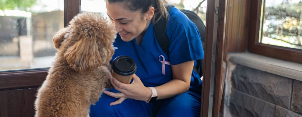 Nurse greeting dog when she gets home from work